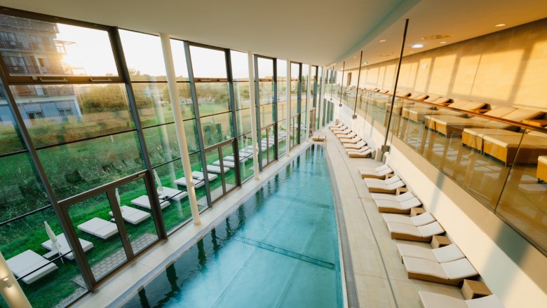 Therme Laa, © Thermenresort Laa / Pflanzl Media Innenansicht eines modernen Thermalbads mit Pool und Liegestühlen.