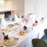 Villa Schönthaler, Küche, © Event Residenzen Niederösterreich Eleganter Frühstückstisch in moderner Küche mit gedecktem Tisch, Geschirr und Speisen.