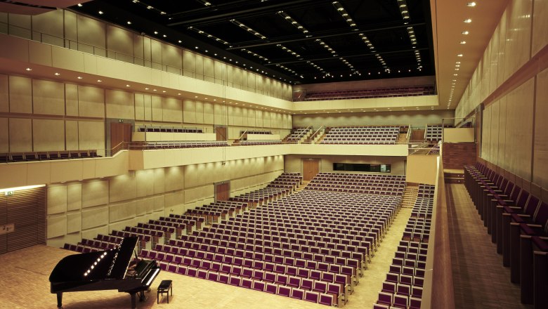 Schloss Grafenegg, Auditorium, © Alexander Koller Innenansicht des Auditoriums im Schloss Grafenegg mit leeren Sitzreihen und einem Flügel auf der Bühne.