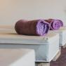 Wellness in den Wiener Alpen, © Heldentheater, Hotel Molzbachhof Wellnessbereich mit lila Handtüchern auf Liegen.