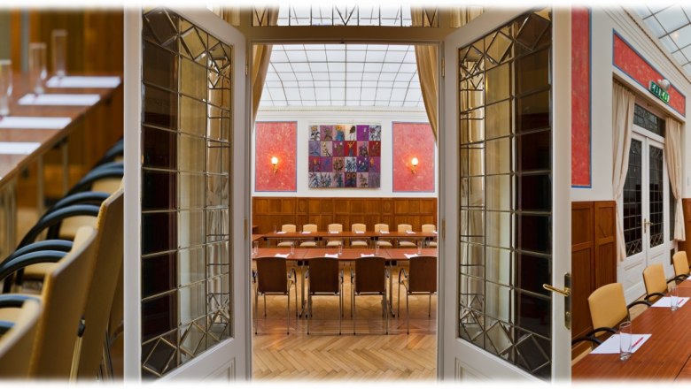 Hotel Herzoghof, © Hotel Herzoghof GmbH, Rainer Mirau Konferenzraum im Hotel Herzoghof mit langen Tischen, Stühlen und Präsentationsausstattung.