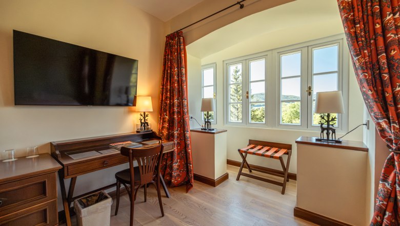 Hotel & Restaurant Knappenhof, © Niederösterreich Werbung / Maximilian Pawlikowsky Hotelzimmer mit Schreibtisch, Stuhl, Fernseher und Fenster mit Aussicht.