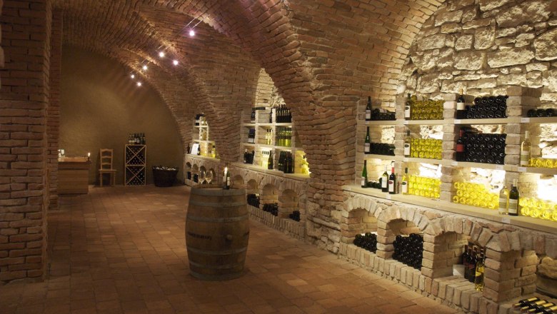 Schlossvinothek, © )Schlosshotel Mailberg Weinkeller mit Ziegelgewölbe und Weinflaschen in Regalen.