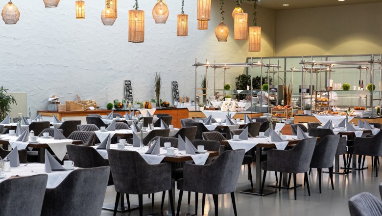 Eventhotel Pyramide, Restaurant Hemingway, © Eventhotel Pyramide GmbH Innenansicht eines stilvollen Restaurants mit gedeckten Tischen und hängenden Lampen.