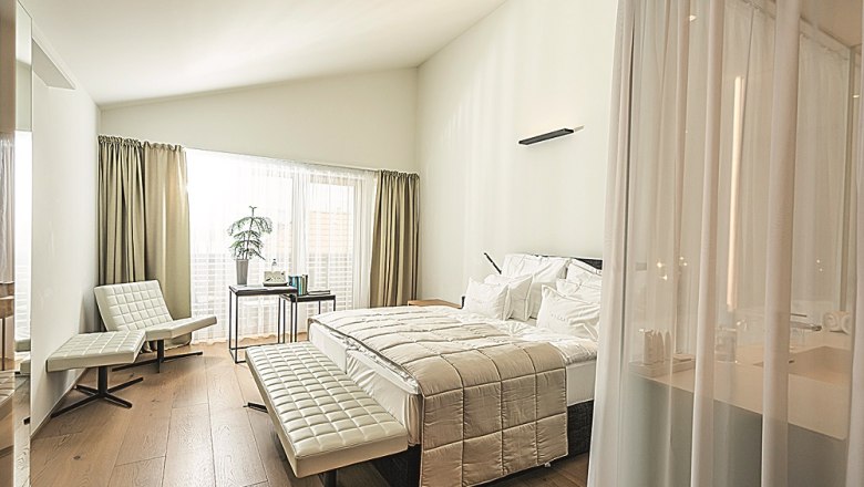 MÖRWALD, Relais Chateaux Hotel am Wagram, © pov.at Modernes Hotelzimmer mit großem Bett, weißen Möbeln und Holzboden.