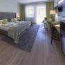Gartenzimmer Superior, © Hotel Schneeberghof, Robert John Elegantes Hotelzimmer mit Doppelbett, Sitzbereich und großem Fenster.