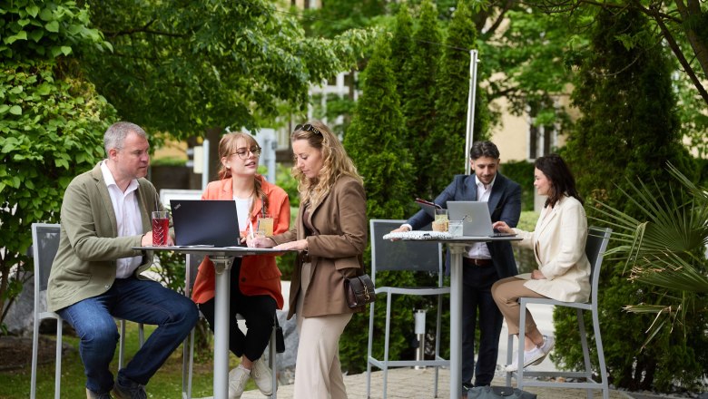 Convention Bureau St. Pölten, © Rupert Pessl Menschen arbeiten im Freien an Stehtischen mit Laptops.