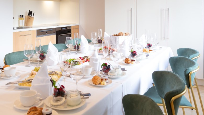Villa Schönthaler, Küche, © Event Residenzen Niederösterreich Eleganter Frühstückstisch in moderner Küche mit gedecktem Tisch, Geschirr und Speisen.