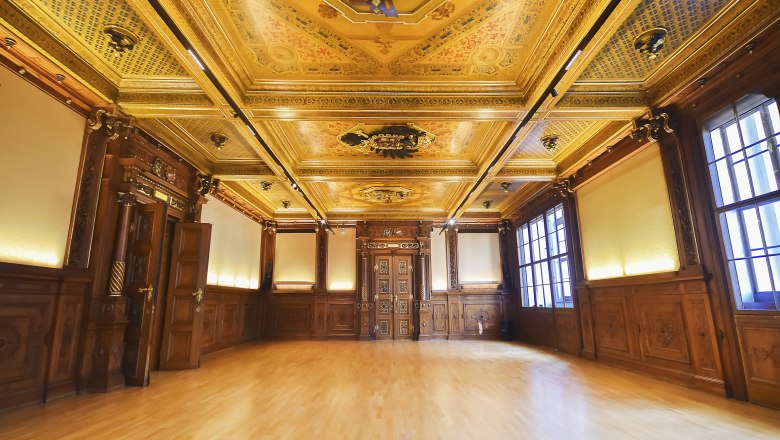 Palais Niederösterreich, Herrensaal, © Event Residenzen Niederösterreich Prunkvoller Saal mit reich verzierter Holzdecke und Wänden im Palais Niederösterreich.