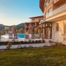 Außenbereich des Naturhotel Molzbachhof, © Heldentheater Außenbereich des Naturhotel Molzbachhof mit Pool und Liegestühlen bei Sonnenuntergang.