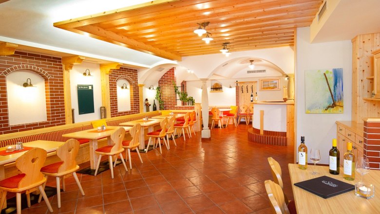 Restaurant, © Hotel Stich Gemütliches Restaurant mit Holzmöbeln und Ziegelwänden.