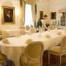 Gelber Salon, © www.thomaskirschner.com Eleganter Speisesaal mit gedecktem Tisch, Kerzenleuchtern und zwei Kellnern.