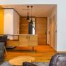 Suite Hotel Klinglhuber, © Franz Klinglhuber GmbH Innenansicht einer modernen Hotelsuite mit Holzboden, grauem Sofa und hölzernem Schreibtisch.