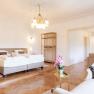 Villa Schönthaler, © Event Residenzen Niederösterreich Elegantes Schlafzimmer mit Doppelbett, Kronleuchter und Kamin.