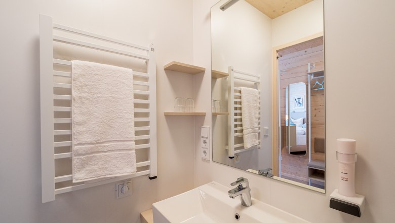 Badezimmer, © freilich / IsaBella Fritsche Modernes Badezimmer mit Handtuchhalter, Spiegel und Waschbecken.