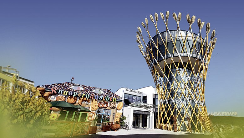 Haubiversum, © Haubis GmbH Außenansicht des Haubiversums mit einem Turm und einem Knusperhäuschen.