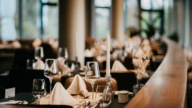 Restaurant im Hotel der Therme Laa, © Victor Liska Elegantes Restaurant mit gedecktem Tisch, Weingläsern und Kerzen.