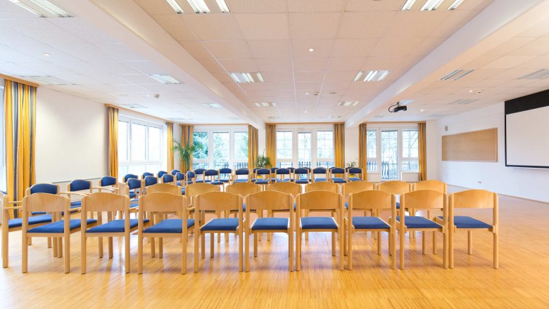 Flackl-Wirt - Seminarraum, © Flackl - Wirt GmbH & Co KG Ein heller Seminarraum mit Stuhlreihen, großen Fenstern und einem Projektor an der Decke.