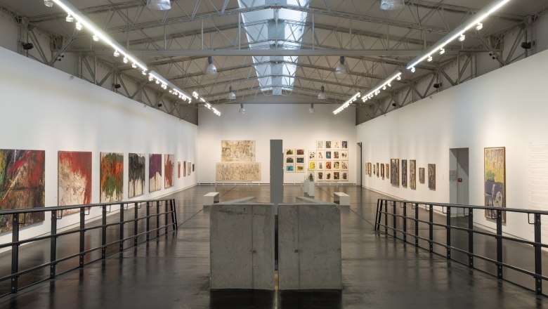 Innenansicht des Nitsch Museums mit Gemälden an den Wänden und moderner Architektur.
