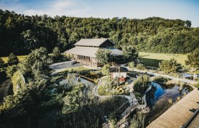 Au&szlig;enansicht des Linsberg Asia Resorts mit Garten und Teich.