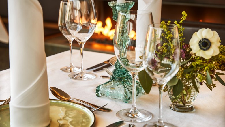 Elegante Tischdekoration mit Gl&auml;sern, Kerzenhalter und Blumen im Steigenberger Krems Restaurant.