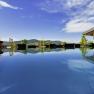 Ein moderner Pool auf einem Penthouse mit Blick auf Berge und blauen Himmel.