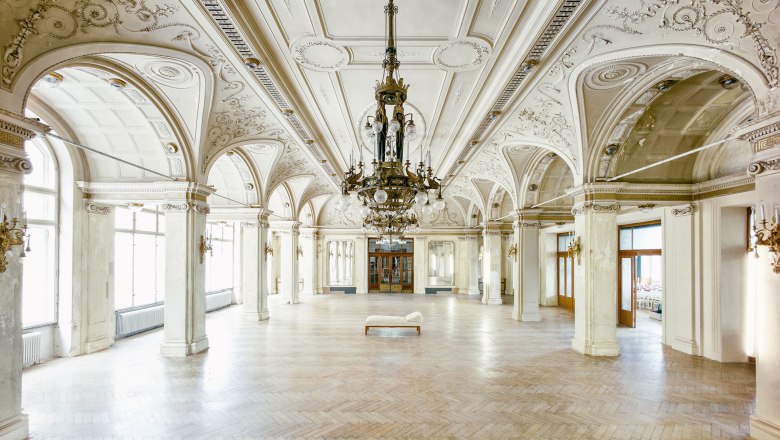 Großer, eleganter Speisesaal mit verzierten Decken und Kronleuchtern im Südbahnhotel.