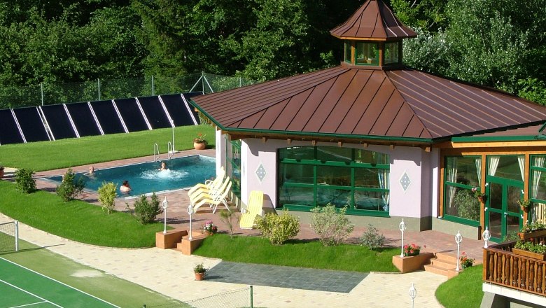 Au&szlig;enansicht eines Wellnessbereichs mit Pool und Pavillon im Gr&uuml;nen.