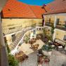Innenhof der Residenz Wachau mit Tischen, St&uuml;hlen und einem Brunnen.
