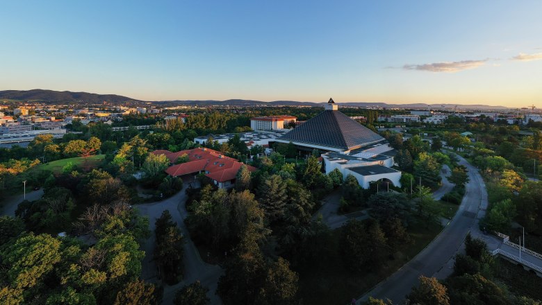 Luftaufnahme des Eventhotel Pyramide mit umliegender Landschaft bei Sonnenuntergang.