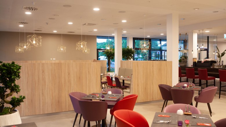 Bunte M&ouml;bel stehen in einer hellen Hotellounge