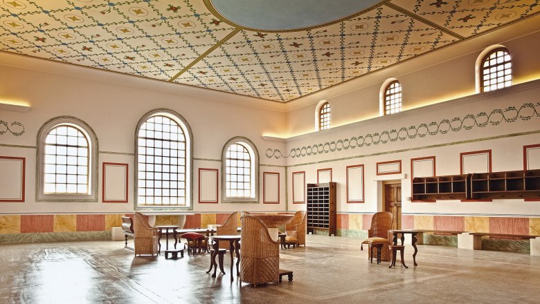 Innenansicht der R&ouml;merstadt Carnuntum Therme mit dekorativer Decke und antiken M&ouml;beln.