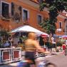 Radfahrer vor einem Hotel mit Terrasse und Sonnenschirmen.