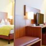 Doppelzimmer im Wachauerhof mit Bett, Schreibtisch, Fernseher und Stuhl.