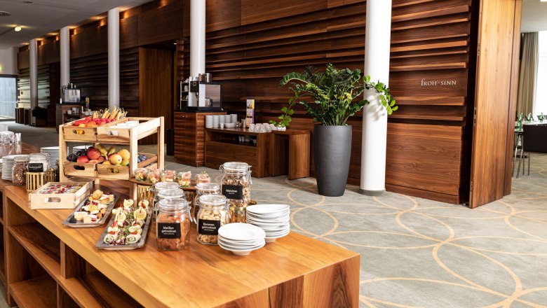 Buffet mit Snacks und Getränken in einem modernen Seminarraum.
