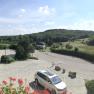 Panoramablick von einem Hotelbalkon auf eine l&auml;ndliche Landschaft mit H&uuml;geln und Wiesen.