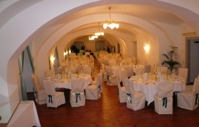 Eleganter Festsaal mit gedeckten Tischen und Stühlen im Schloss Gloggnitz.