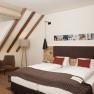 Gem&uuml;tliches Hotelzimmer mit Doppelbett, Sitzbereich und Dachschr&auml;ge.