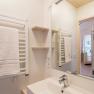 Modernes Badezimmer mit Handtuchhalter, Spiegel und Waschbecken.