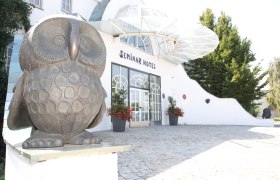 Eingang eines Seminarhotels mit Eulenskulptur.