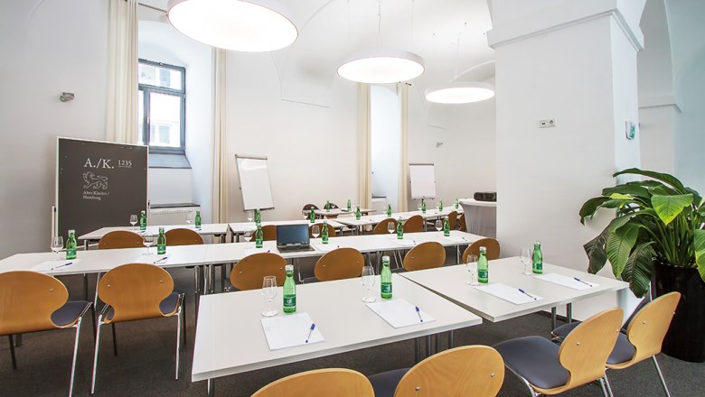 Konferenzraum im Hotel Altes Kloster mit Tischen, St&uuml;hlen und Flipcharts.