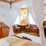 Gemütliches Doppelzimmer mit Himmelbett, Holzmöbeln und Schreibtisch.