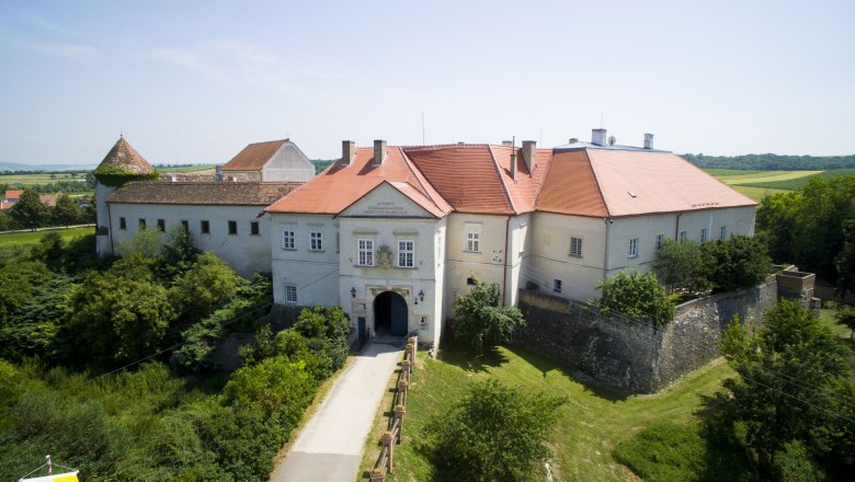 Luftaufnahme von Schloss Mailberg mit roten D&auml;chern und umgebender Landschaft.