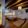 Gem&uuml;tliches Zimmer mit Holzboden, Doppelbett, Dusche und moderner Einrichtung.