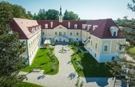 Luftaufnahme von Schloss Haindorf mit Innenhof und Garten.