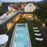 Luftaufnahme eines modernen Hauses mit Pool und Garten bei Abendd&auml;mmerung.