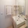 Modernes Badezimmer mit Waschbecken, Spiegel und Handtuchhalter.
