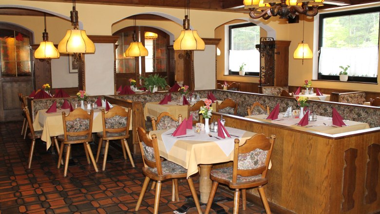 Gem&uuml;tliches Restaurant mit Holzm&ouml;beln und gedeckten Tischen.