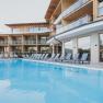 Modernes Hotel mit Pool und Liegest&uuml;hlen im Freien.