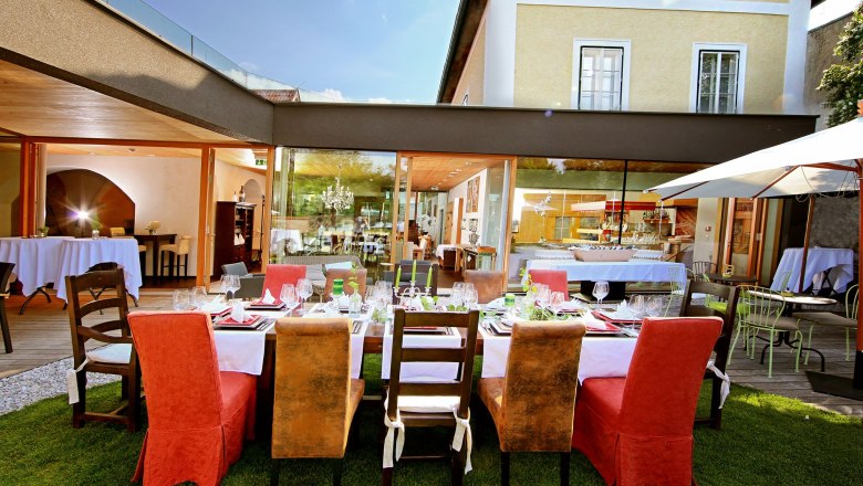 Elegantes Restaurant mit gedecktem Tisch im Freien, umgeben von modernen Geb&auml;uden.